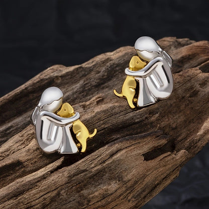 A little girl and a dog embrace earrings